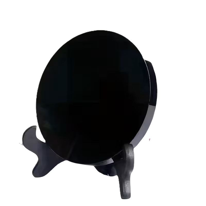 Scrying miirror sians emporium A polished black obsidian scrying mirror displayed on a decorative stand against a white background traditionally used for mirror scrying and spiritual divination